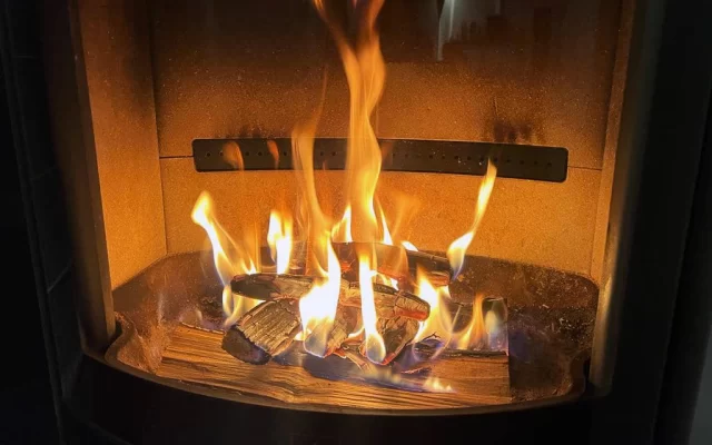 Liepsna virš kelių malkų pliauskų krosnelės degimo kameroje
